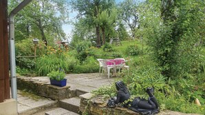 A garden with a stone staircase, a bench, and a statue.