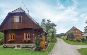 A rustic wooden house with a sloped roof, a porch with a wooden bench, and flower boxes on the windows. - Awesome Home in Deutschlandsberg With 1 Bedrooms and Wifi (Deutschlandsberg)