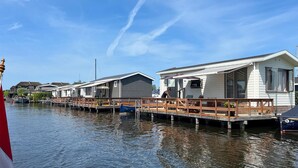 A row of mobile homes with a wooden dock extending into a calm body of water. - Stunning Home in Breukelen With 2 Bedrooms and Wifi (Breukelen)