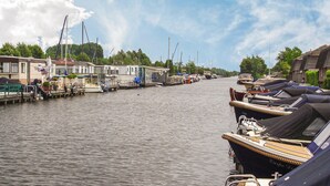 A canal with boats docked on both sides, a row of houses along the water, and a clear sky. - Stunning Home in Breukelen With 2 Bedrooms and Wifi (Breukelen)