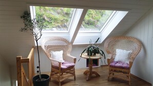 A room with two wicker chairs, a small round table, and a potted plant. - Nice Apartment in Fitjar With 2 Bedrooms and Wifi (Fitjar)