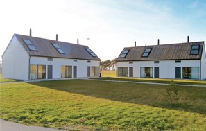 Two modern, white buildings with sloped roofs and skylights.