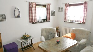 A cozy living room with two armchairs, a small table, and a purple ottoman. - Amazing Apartment in Koserow With 2 Bedrooms and Internet (Koserow)
