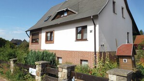 A two-story house with a sloped roof, brick lower half, and white upper half. - Amazing Apartment in Koserow With 2 Bedrooms and Internet (Koserow)