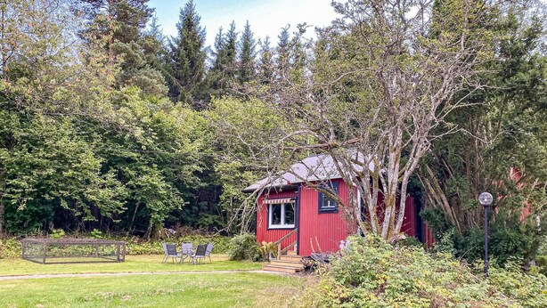 A red cabin with a small porch and a table with chairs in front. - Stunning Home in Hishult With Wifi and 2 Bedrooms (Hishult)