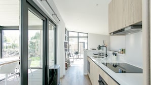 Una cocina moderna con una isla central, ventanas amplias y vistas al exterior.