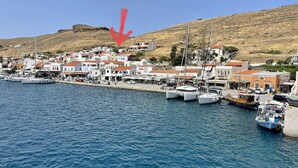 A coastal town with a marina, white buildings with red roofs, and a hill in the background. - Charming two Bedroom Fisherman's House on Kea (Kea)