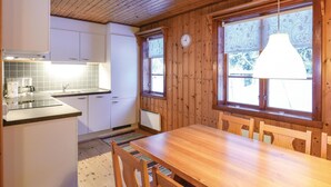 A wooden interior with a kitchen area, a dining table, and large windows. - Amazing Home in Sysslebäck With 2 Bedrooms and Wifi (Sysslebäck)