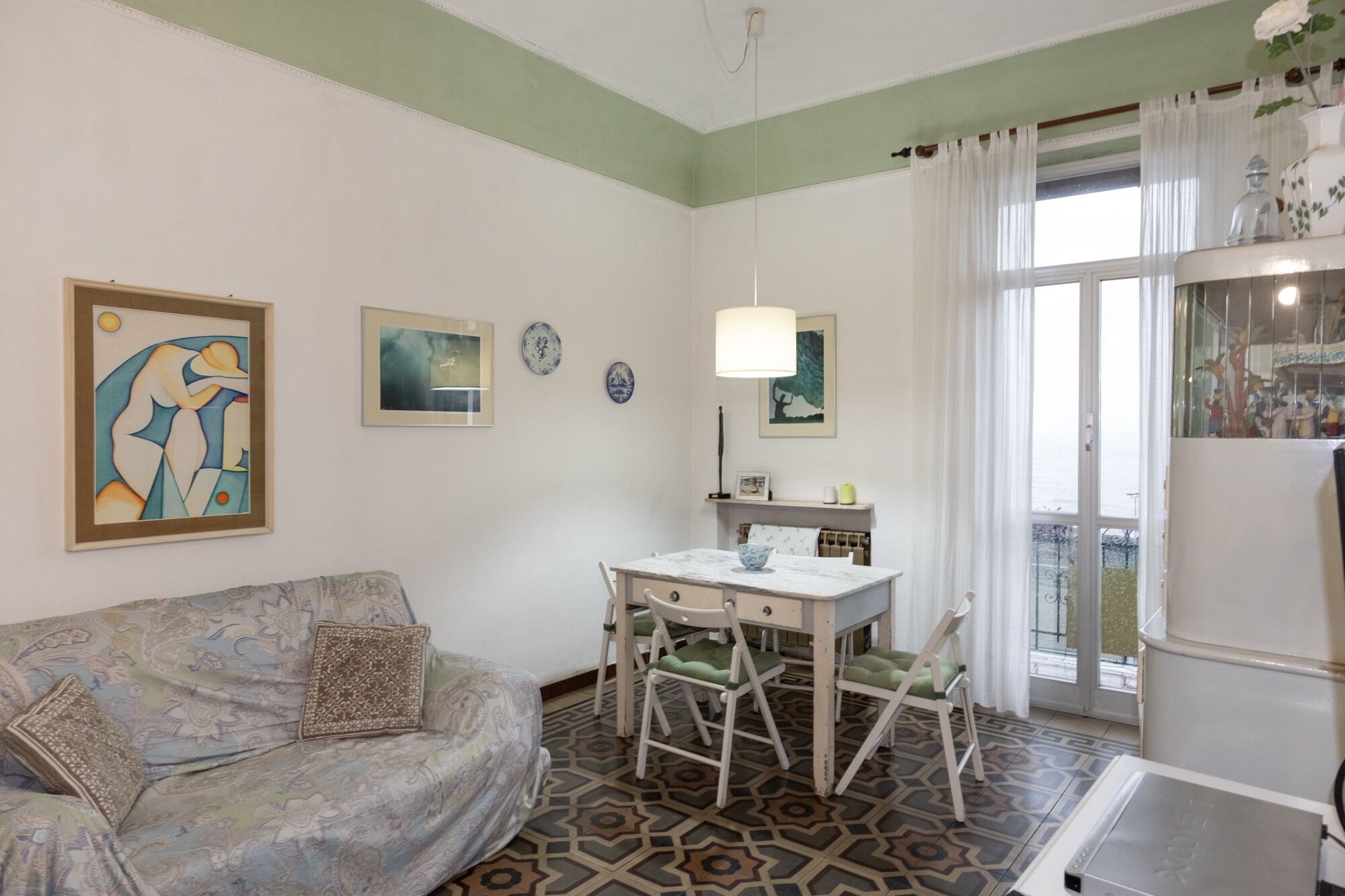 Una sala de estar acogedora con un sofá, una mesa de comedor con sillas y una zona de cocina con un refrigerador.