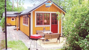 Eine kleine Holzhütte mit roter Tür, großen Fenstern und einer Flagge.