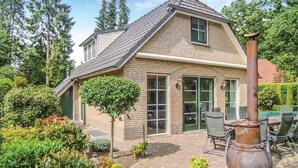 Une maison à deux étages, dotée d’un toit en pente, de grandes fenêtres et d’une façade en briques.