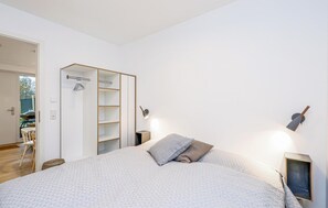 A bedroom with a bed, a wardrobe, a desk, and a chair. - Amazing Apartment in Lembruch/dümmer See With 2 Bedrooms, Wifi and Indoor Swimming Pool (Lembruch)