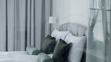 A modern hotel room with a large bed, a bedside table, and a lamp.