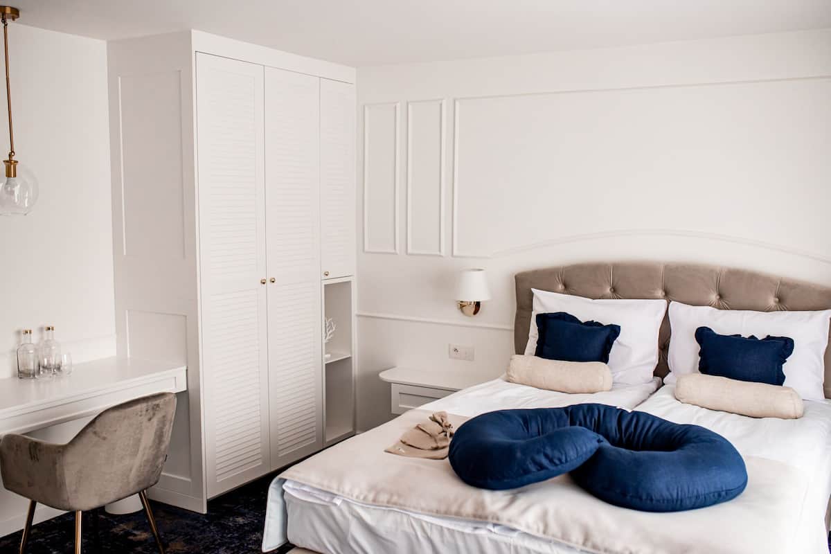 A bedroom with a bed, a desk, and a chair.