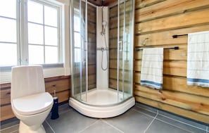 A corner bathroom with a glass-enclosed shower, a toilet, and wooden paneling on the walls. - Amazing Home in Rauland With Sauna, Wifi and 4 Bedrooms (Vinje)