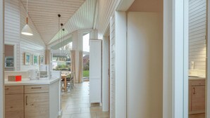 A modern kitchen with white cabinetry, a dining area with a table and chairs, and a view of the outdoors through large windows. - Awesome Home in Krems Ii/warderbrück With 3 Bedrooms, Sauna and Wifi (Krems II)