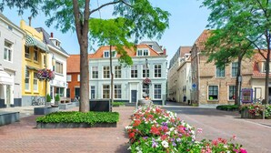 A street with historic buildings, a central flower bed, and a pedestrian pathway. - Awesome Home in Heinkenszand With Wifi, 4 Bedrooms and Outdoor Swimming Pool (Heinkenszand)