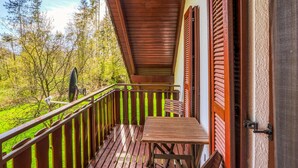 A wooden balcony with a table and chairs, overlooking a green landscape with trees. - Awesome Home in Kirchheim With 4 Bedrooms, Sauna and Wifi (Kirchheim)