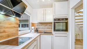 A modern kitchen with white cabinets, a built-in oven, and a coffee maker. - Awesome Home in Kirchheim With 4 Bedrooms, Sauna and Wifi (Kirchheim)