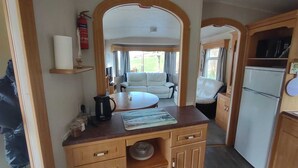 Cocina compacta para camper con encimera de madera, un fregadero y un refrigerador.