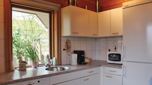 A kitchen with white cabinets, a Bosch dishwasher, a microwave, and a coffee maker. - Amazing Home in Hulshorst With 3 Bedrooms and Wifi (Hulshorst)