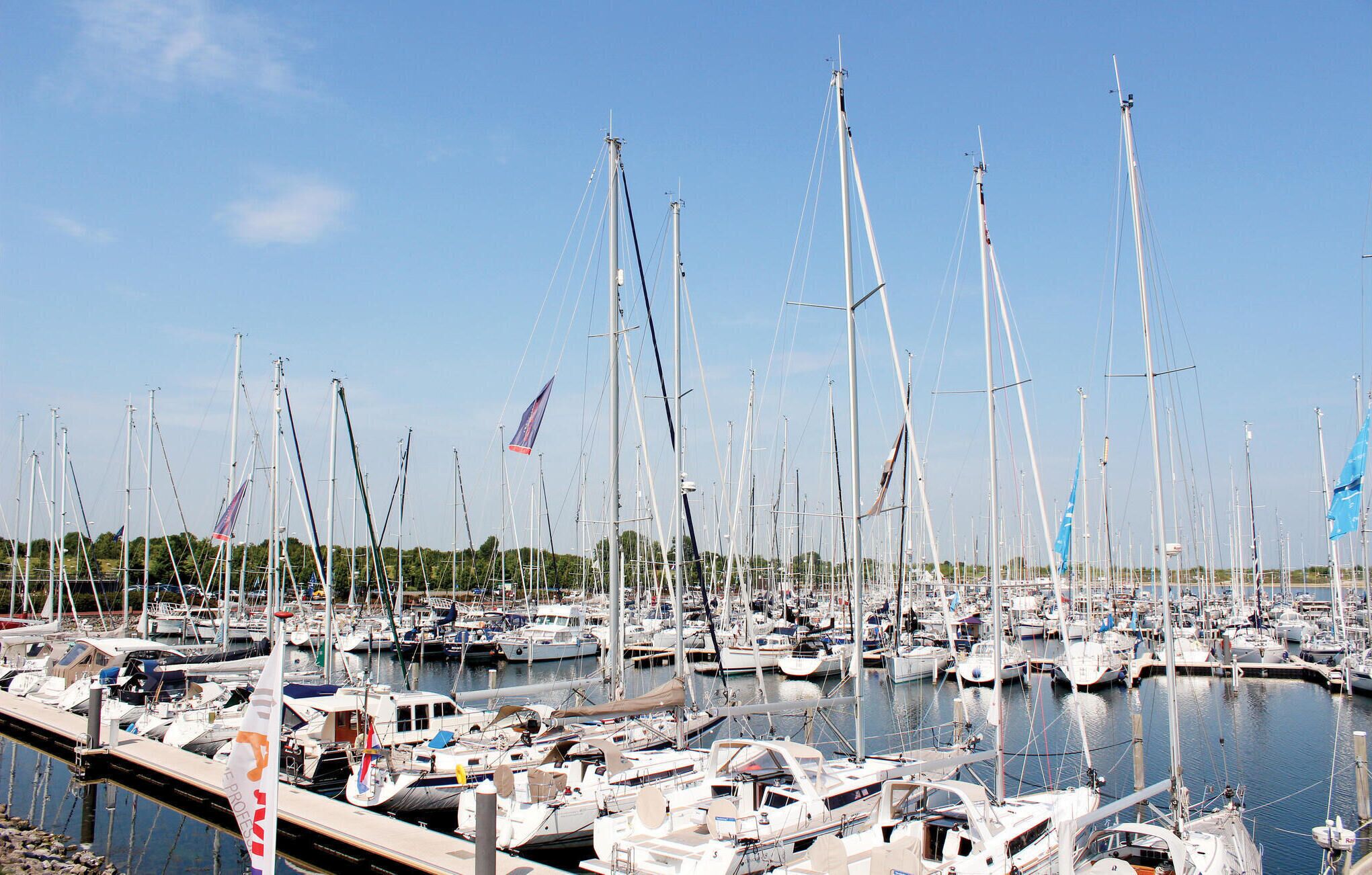 A marina filled with numerous sailboats docked at the pier.