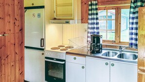 Eine Küche mit Kühlschrank, Herd, Backofen und Kaffeemaschine.