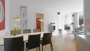 A modern hotel room with a dining area, a living area, and a view of the outside. - Awesome Apartment in Lübeck Travemünde With 2 Bedrooms, Sauna and Wifi (Lübeck)