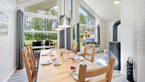 A dining area with a wooden table set for four, large windows, and a view of the outdoors. - Stunning Home in Krems Ii/warderbrück With 3 Bedrooms and Sauna (Krems II)