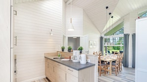A modern kitchen with wooden cabinets, a central island, and a dining area with wooden chairs. - Stunning Home in Krems Ii/warderbrück With 3 Bedrooms and Sauna (Krems II)