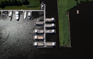 An aerial view of a marina with several docked boats and a small island with a dock.