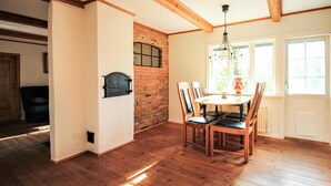Un comedor con pared de ladrillo, suelo de madera y una mesa con sillas.