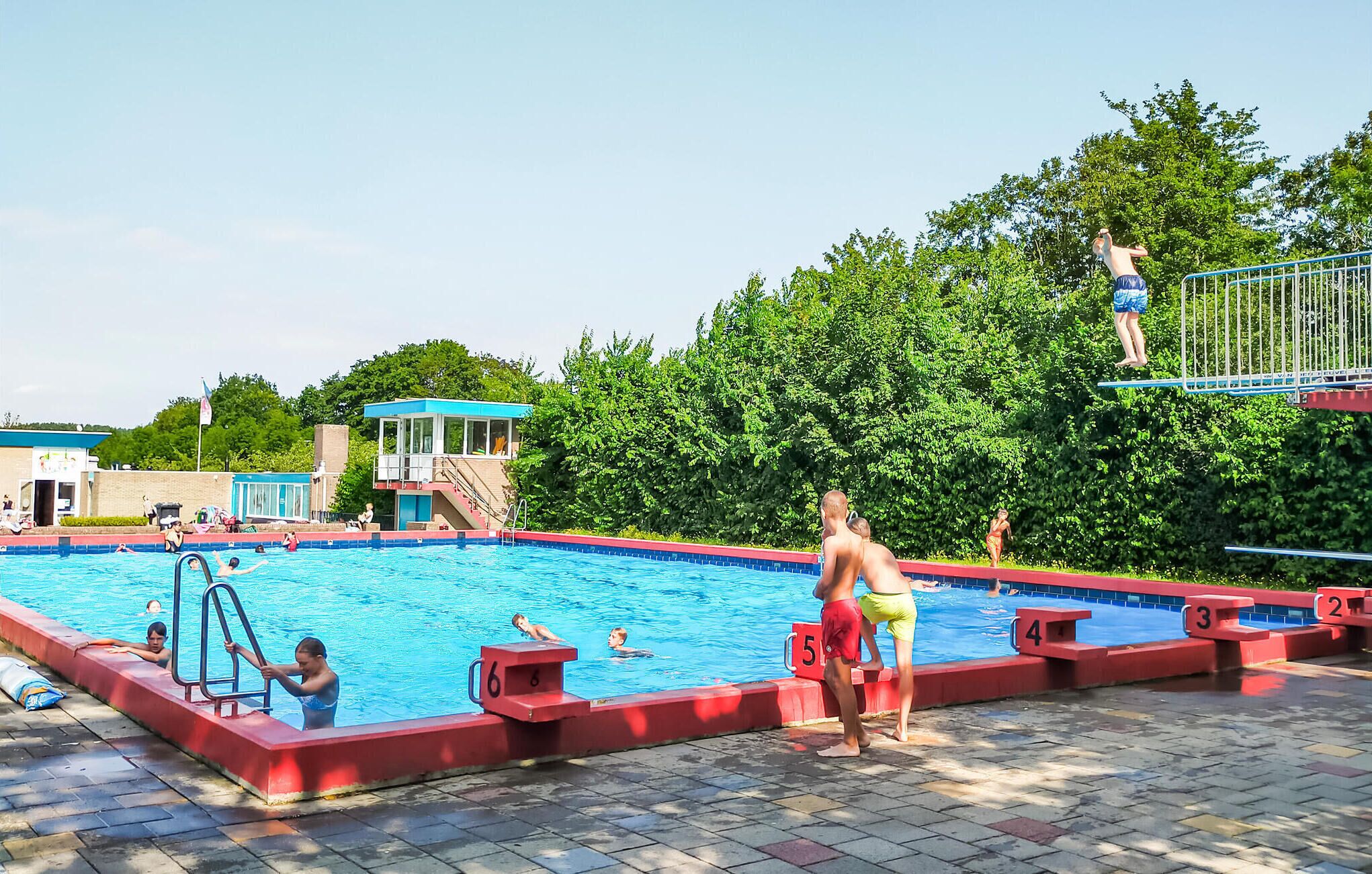 A swimming pool with diving platforms and a lifeguard tower.