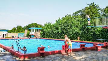 A swimming pool with diving platforms and a lifeguard tower.