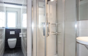Ein modernes Badezimmer mit einer Duschkabine, einer Toilette und einem Waschbecken.