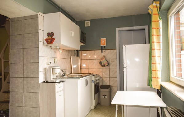 Huis | Privékeuken | Een koelkast, kookgerei, borden en bestek