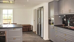 A modern kitchen with grey cabinets, stainless steel appliances, and a large window providing natural light. - Awesome Home in Lammhult With 5 Bedrooms, Sauna and Wifi (Lammhult)