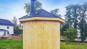 A wooden structure with a chimney, likely a sauna or hot tub, in a backyard with a house and trees in the background. - Awesome Home in Lammhult With 5 Bedrooms, Sauna and Wifi (Lammhult)