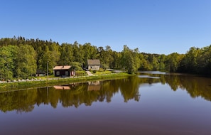 A lakeside cabin with a small dock, surrounded by dense forest and a calm lake reflecting the scenery. - Nice Home in Munkedal With 2 Bedrooms and Wifi (Munkedal)