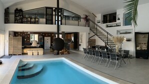 A spacious indoor swimming pool with a high ceiling and a mezzanine level. - Domaine des Vergers (Cavaillon)
