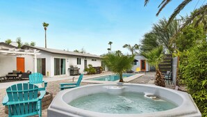 A backyard with a hot tub, outdoor seating, and a pool. - Holiday Pool Paradise - A Ryson Property (Palm Springs)