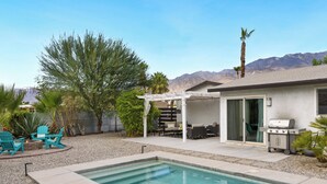 A backyard with a swimming pool, outdoor seating, and a barbecue grill. - Holiday Pool Paradise - A Ryson Property (Palm Springs)