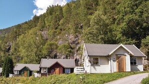A row of cabins with a mountain backdrop, a gravel driveway, and a clear sky. - Awesome Home in Vallavik With 3 Bedrooms and Wifi (Ulvik)