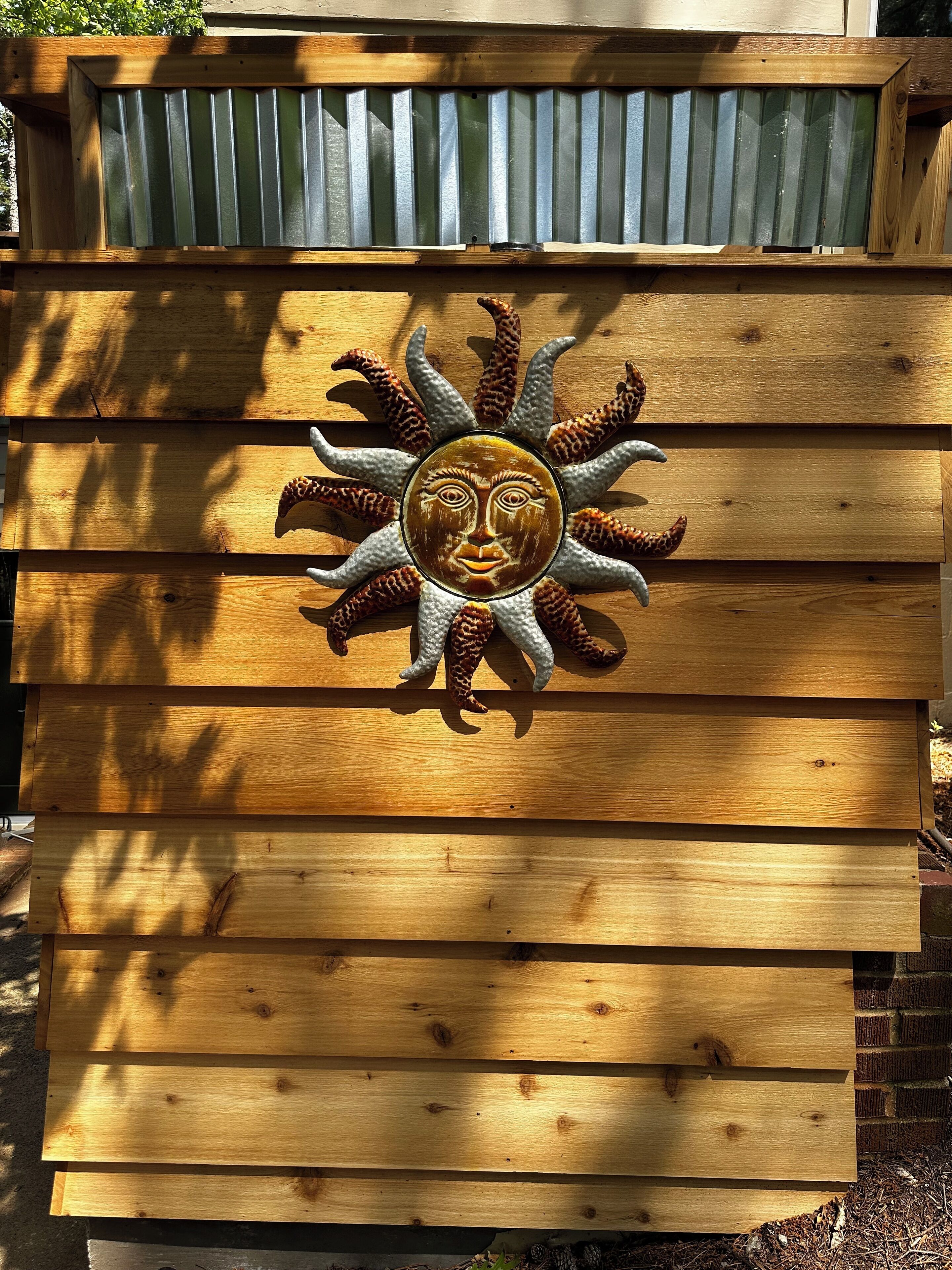 A wooden structure with a decorative sun design.
