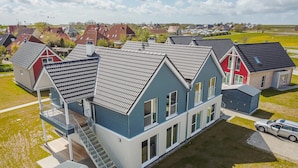 A residential area with houses featuring gabled roofs and a central blue house with a visible staircase. - Beautiful Apartment in Büsum With 2 Bedrooms, Sauna and Wifi (Büsum)