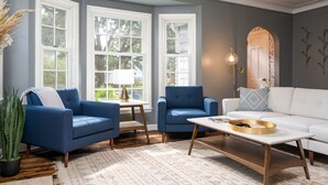 A living room with a blue armchair, a white sofa, a coffee table, and a floor lamp. - MINNeSTAY* Shoreline Villa | Pool (Robbinsdale)