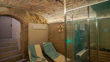 Cozy retreat with two single beds, a seating area, and a glass partition separating the space.