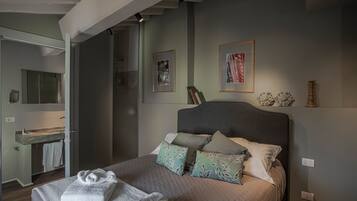 A bedroom with a bed, pillows, and a bedside table.