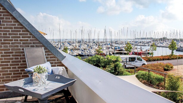 Un balcon donnant sur une marina où sont amarrés de nombreux bateaux.