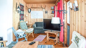 A cozy cabin interior with a television, wooden furniture, a map on the wall, and a sign indicating 'Appelsintreet 1.5 km'. - Beautiful Home in Gol With 2 Bedrooms (Gol)
